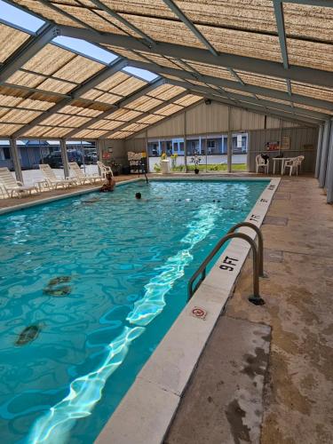 een groot zwembad met een open plafond bij Great Lakes Inn Mackinaw City in Mackinaw City