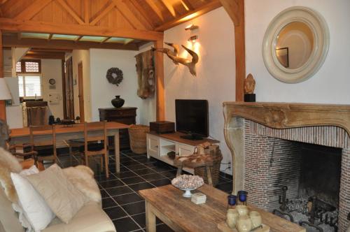 a living room with a fireplace and a table at Vakantiehuis 't Verloren Schaap Damme in Damme