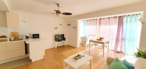 een woonkamer met een bank en een tafel en een keuken bij Apartamento primera línea con acceso privado a la playa in Altea