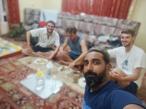 a group of men sitting around a table at New urban Den cottage in Srinagar