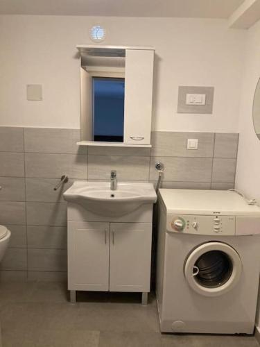 a bathroom with a washing machine and a sink at Apartment Mate Wohnung 2 in Stobreč