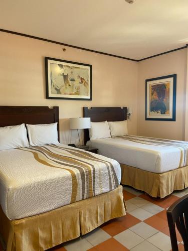 a hotel room with two beds and a table and chairs at Hotel La Recolección in León