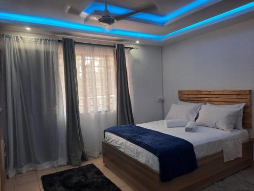 a bedroom with a bed with blue lights on the ceiling at Seaesta Studio Diani Beach in Diani Beach