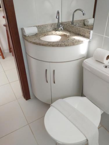 a bathroom with a toilet and a sink at Recanto Taperapuan Residencial Mont Carmelo in Porto Seguro