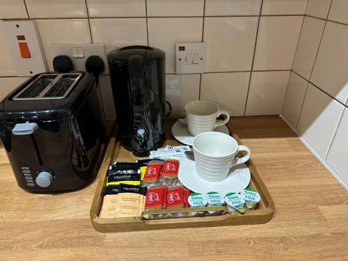 a tray with cups and coffee on a counter next to a coffee maker at Premium Studio Flat 02 Near Tower Bridge in London