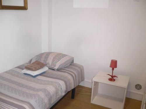 une petite chambre avec un lit et une table de chevet dans l'établissement En plein centre historique et piétonnier, à Rouen