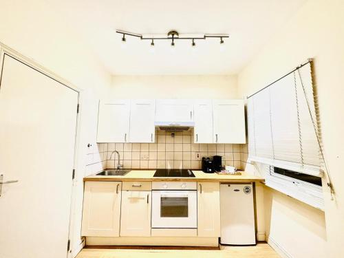 a small kitchen with white cabinets and a sink at Premium Studio Flat 05 Near Tower Bridge in London