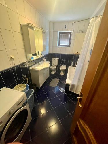 ein Badezimmer mit 2 WCs, einem Waschbecken und einer Waschmaschine in der Unterkunft Apartman Centar Sarajevo in Sarajevo