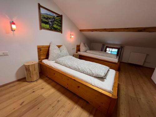 two beds in a room with wooden floors at Bioberghof Rohr in Fieberbrunn