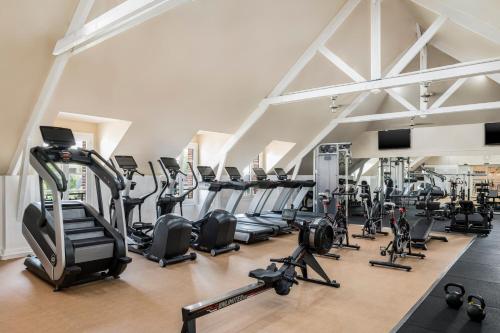 a gym with rows of treadmills and elliptical machines at Marriott's Village d'Ile-de-France in Bailly-Romainvilliers