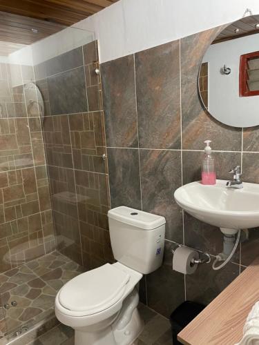a bathroom with a toilet and a sink at Ancestral Casa de Campo in Roldanillo