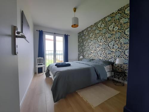 1 dormitorio con 1 cama con colcha azul en Gîte à la ferme avec sauna, forêt de Fontainebleau, en Milly-la-Forêt