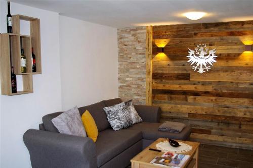 a living room with a couch and a wooden wall at Sellraintaler Auszeit 1 in Sellrain