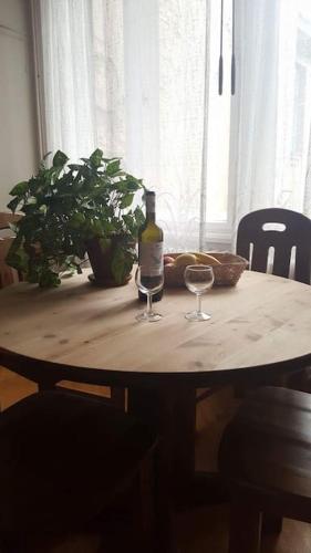 a table with a bottle of wine and two glasses at Sugar House City Center Apartment in Budapest