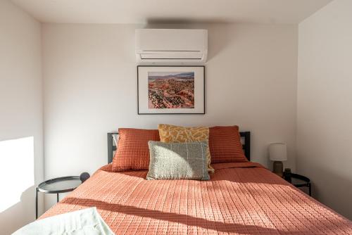 a bedroom with a bed with an orange comforter at Casitas at Capitol Reef in Torrey