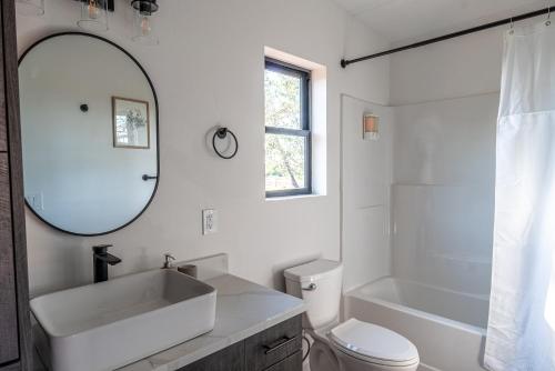 a white bathroom with a sink and a mirror at Casitas at Capitol Reef in Torrey