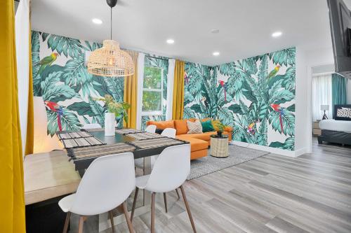 a dining room with a table and chairs and a couch at Vacay Spot Wynwood Retreat 6 to 42 Guests 6 Kitchens Shower Massage jets, BBQ, Patio LED vibes, Prime LOC! 6 blocks away 4rm Bars, Nite Clubs, Res, Shops in Miami