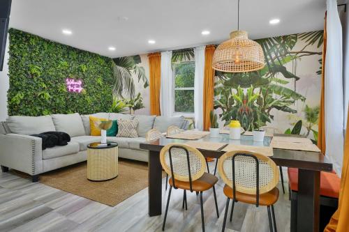 a living room with a couch and a table and chairs at Vacay Spot Wynwood Retreat 6 to 42 Guests 6 Kitchens Shower Massage jets, BBQ, Patio LED vibes, Prime LOC! 6 blocks away 4rm Bars, Nite Clubs, Res, Shops in Miami