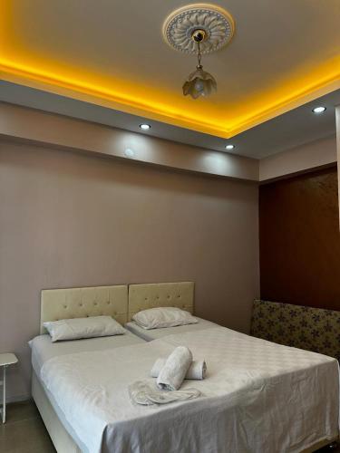 um quarto com uma cama grande com lençóis brancos e um tecto em Mardin Expert Otel em Mardin