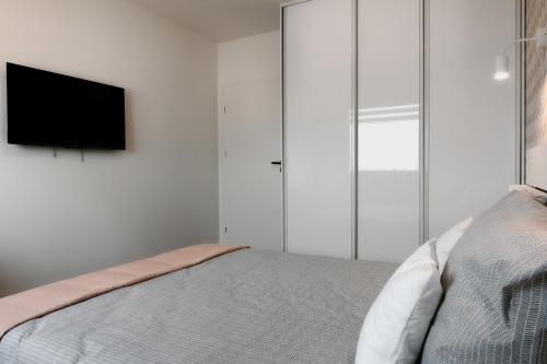 a bedroom with a bed with a flat screen tv at Jak u siebie w domu. Apartament w nowej dzielnicy. in Tczew