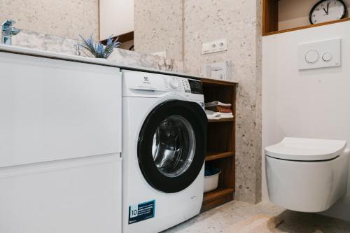 a washing machine in a bathroom next to a toilet at Jak u siebie w domu. Apartament w nowej dzielnicy. in Tczew