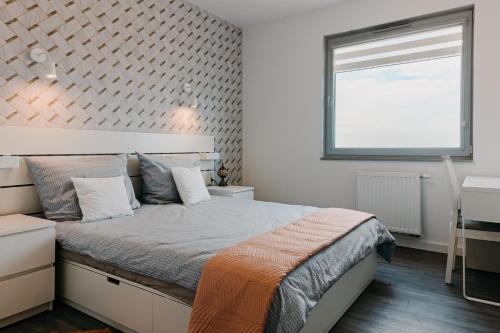 a bedroom with a bed and a window and a desk at Jak u siebie w domu. Apartament w nowej dzielnicy. in Tczew