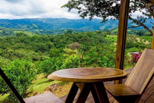 a wooden table and a chair on a porch with a view at Luxury Villa Caoba- Private, Serene, Amazing Views in San Mateo