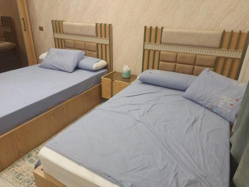 two twin beds in a room with at شقه في جاردينيا الماظه تحتوى على ٣غرف مكيفه وريسبشن وحمام ومطبخ وريسبشن وبلكونه بجوار سنتر الماظه وسنتر سيتي ستارز الدور الثالث ولها موقع متميز وبلكونه تطل علي مول الكمبوند in Cairo