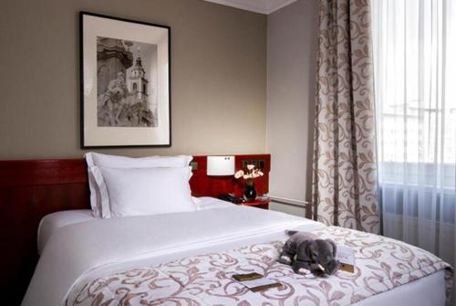 a bedroom with a bed with a stuffed animal on it at GRG Kanha Inn Lucknow in Lucknow