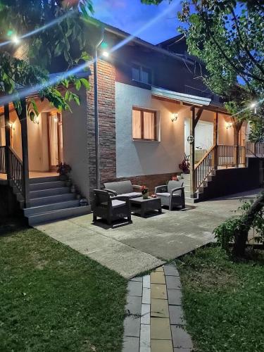 a patio in front of a house at night at IKONIJA guest house in Pečenjevce