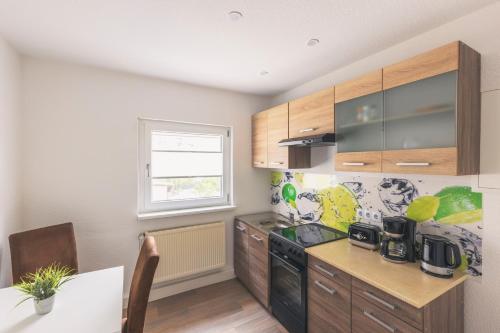 a kitchen with wooden cabinets and a counter top at Gästehaus Ehrhardt in Merseburg