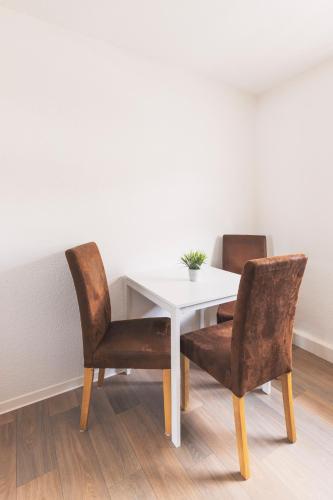 a white table with two chairs and a white table at Gästehaus Ehrhardt in Merseburg