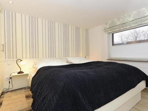 a bedroom with a large bed and a window at Ferienwohnung in Wyk-Boldixum auf Foehr in Boldixum