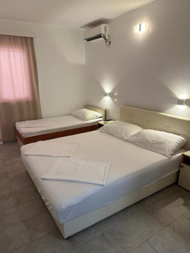 um quarto com duas camas e duas luzes na parede em Apartmani maja lida em Dobra Voda