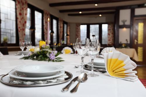 a table with a white table cloth and plates and wine glasses at Jeddinger Hof Land- und Seminarhotel in Visselhövede