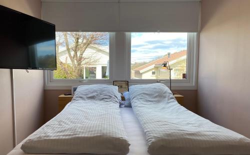 a bedroom with two beds in front of a window at Privat hjem i Grimstad - Nær Arendal og Dyreparken in Grimstad