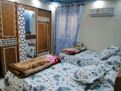 dwa łóżka w pokoju z lustrem w obiekcie برج الهنا w Aleksandrii