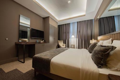 a hotel room with a large bed and a desk at Four Mansions Hotel in Kayseri