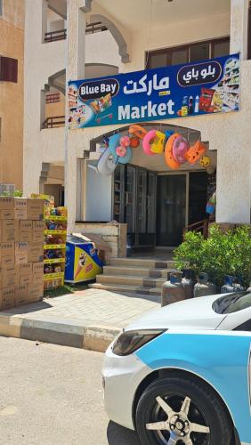 a white car parked in front of a market at اجمل شاليه بقرية بلو باي بمرسى مطروح مكيف غرفتين ورسيبشن best chalet 2 room marsa matrouh blue bay village in Marsa Matruh