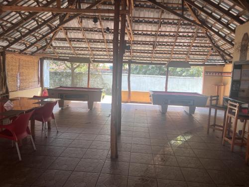 Dinner Bell Lodge في Kitwe: غرفة مع طاولة بلياردو وطاولات وكراسي