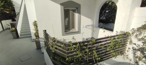 a white house with stairs and a window at Ammos Luxury Studios in Aliki