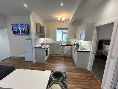 a large kitchen with white cabinets and a living room at Modern design residence in Dublin