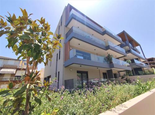a large building with some plants in front of it at Brand new condo next to the beach, peaceful square, garden view in Rethymno Town