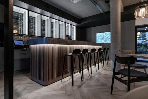 a bar with black stools and a row of windows at Rosa Style in Rowy