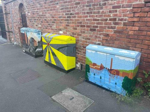 two electrical boxes sitting next to a brick wall at Riverside Victorian home in Neepsend