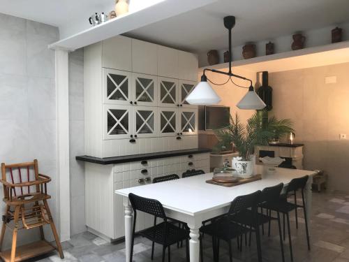 a kitchen with a white table and chairs at La Casona del Tío Pedro in Cadalso de los Vidrios