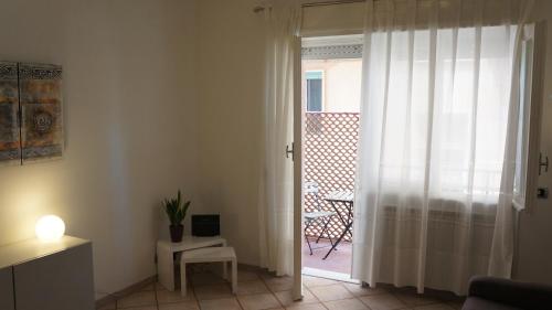 a living room with a door open to a patio at Casetta Seaside in Ladispoli