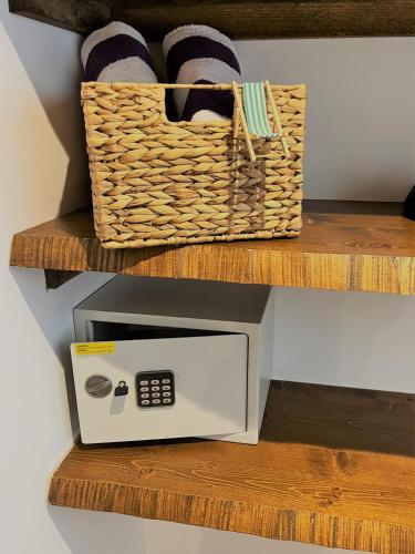 a microwave sitting on a wooden shelf next to a basket at Emilysuites - Malaga Centro Historico in Málaga
