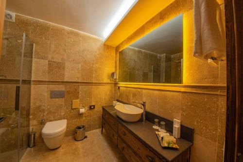 a bathroom with a sink and a toilet and a mirror at Four Mansions Hotel in Kayseri