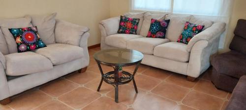 a living room with two couches and a table at Las buganvilias in Pachacamac